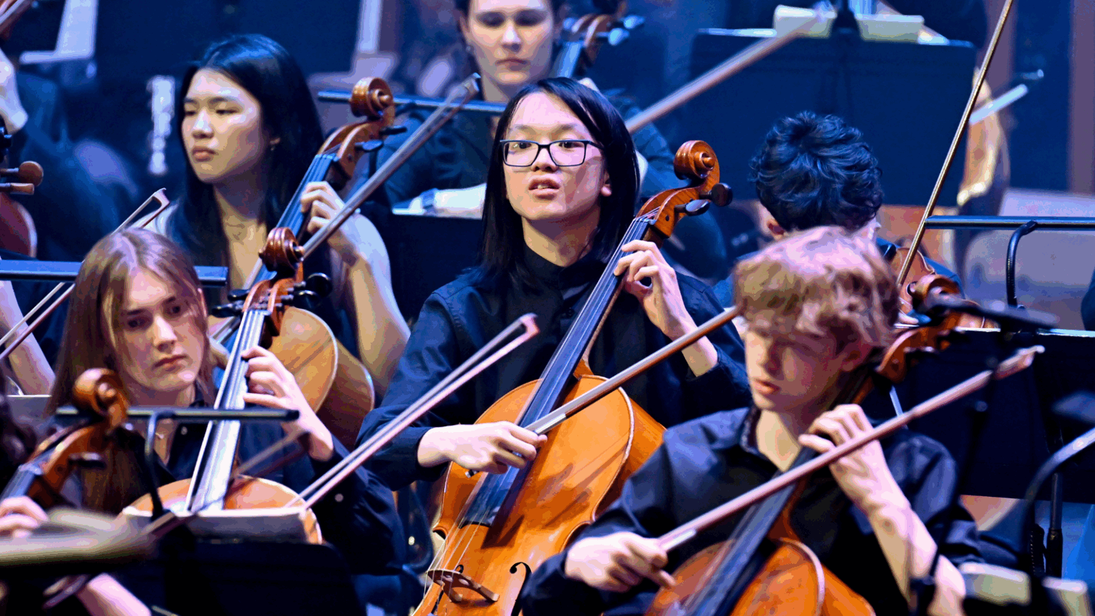 NYO cello players performing on the Barbican stage.
