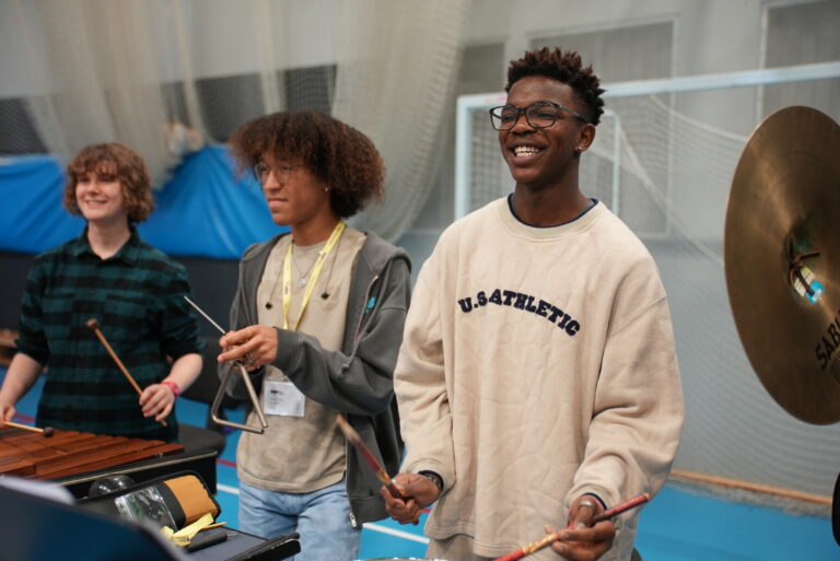 Three teenage musicians play percussion with The National Youth Orchestra.