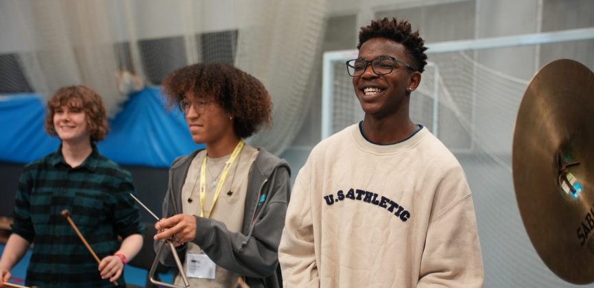 Three teenage musicians play percussion with The National Youth Orchestra at Unite 2023.