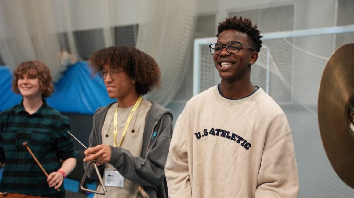 Three teenage musicians play percussion with The National Youth Orchestra at Unite 2023.